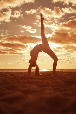 genç güzel ince kadın silueti beac yoga uygulamaları