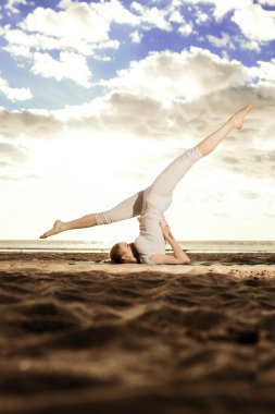 genç güzel ince kadın sunris plaj yoga uygulamaları
