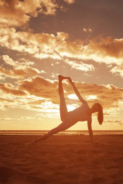 genç güzel ince kadın silueti beac yoga uygulamaları