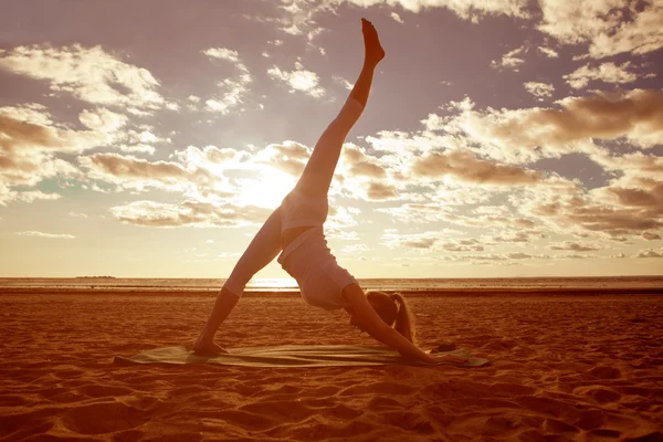 Ung vacker smal kvinna silhuett praxis yoga på stranden — Stockfoto