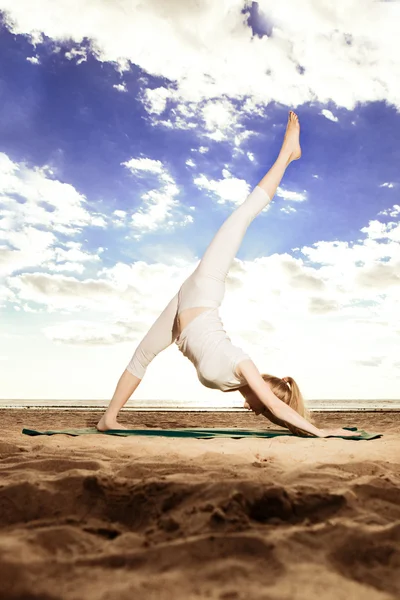 Joven hermosa mujer delgada practica yoga en la playa en Sunris —  Fotos de Stock