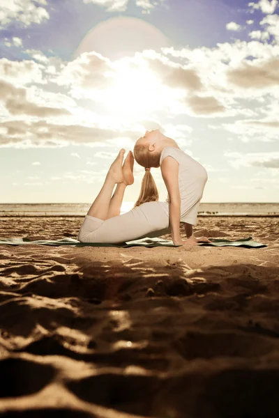 Ung vacker smal kvinna praxis yoga på stranden vid sunris — Stockfoto