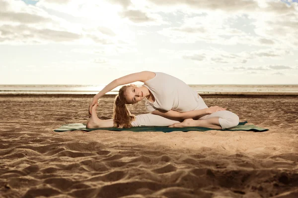 Ung vacker smal kvinna praxis yoga på stranden vid sunris — Stockfoto