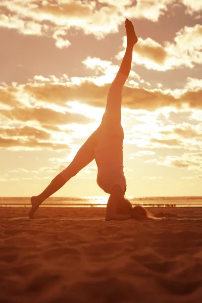 Joven hermosa mujer delgada silueta practica yoga en la playa —  Fotos de Stock