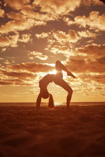 Joven hermosa mujer delgada silueta practica yoga en la playa —  Fotos de Stock