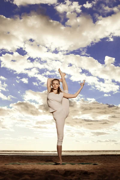 Joven hermosa mujer delgada practica yoga en la playa en Sunris —  Fotos de Stock