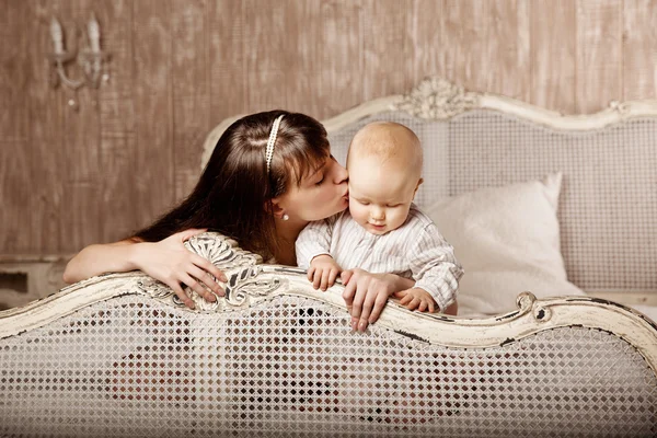 Madre con un niño pequeño en el interior. Sonriente familia en el — Foto de Stock