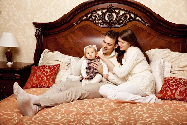 Cute family in the bedroom. Mother, father and daughter in the i — Stock Photo, Image