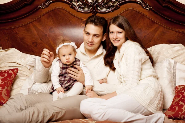 Linda familia en el dormitorio. Madre, padre e hija en la i — Foto de Stock