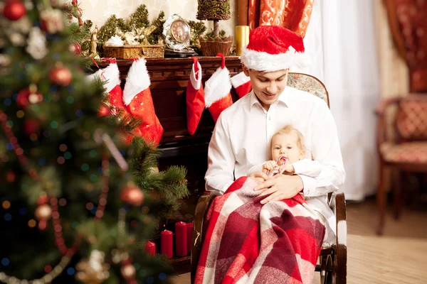 Noel ağacının etrafında oturan aile. Baba ve bebek ne — Stok fotoğraf