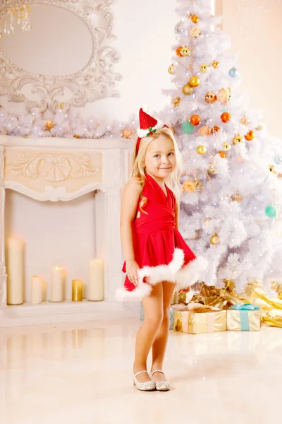 Beautiful little Santa girl near the Christmas tree.  Happy girl — Stock Photo, Image