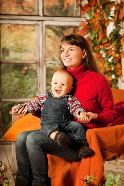 Mulher bonita com uma criança na varanda da frente com abóboras au Fotografias De Stock Royalty-Free