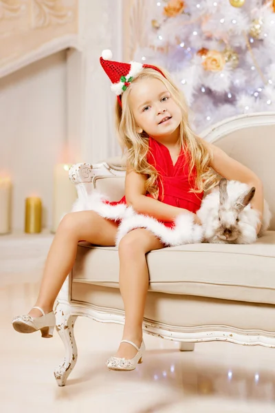 Bella bambina Santa vicino all'albero di Natale. Ragazza felice Foto Stock