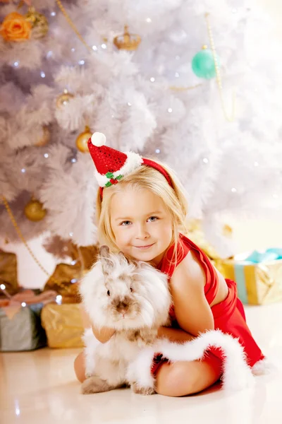 Όμορφο μικρό κορίτσι santa κοντά το χριστουγεννιάτικο δέντρο. ευτυχισμένος κορίτσι Εικόνα Αρχείου