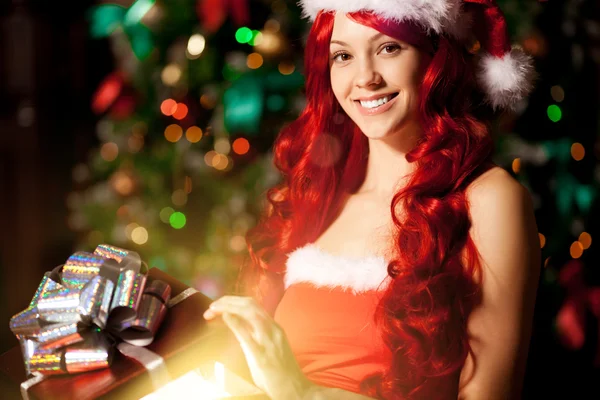 Jeune belle femme souriante santa près du sapin de Noël avec — Photo