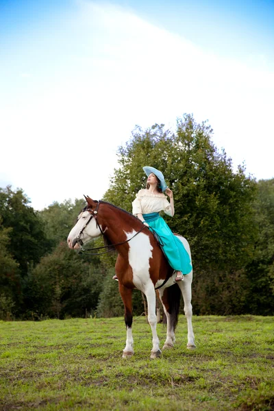 Uma mulher bonita com um cavalo no campo. Menina em uma fazenda com um — Fotografia de Stock