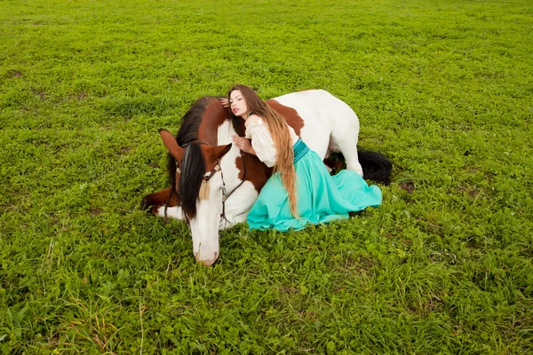 Uma mulher bonita com um cavalo no campo. Menina em uma fazenda com um — Fotografia de Stock