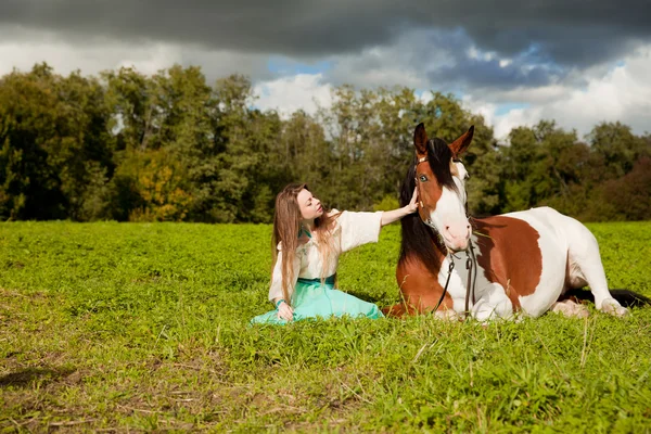 Beautiful woman with a horse in the field. Girl on a farm with a — Stock Photo, Image