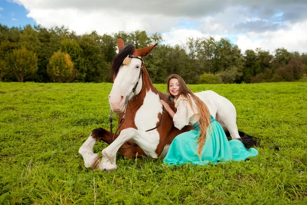 Hermosa mujer con un caballo en el campo. Chica en una granja con un — Foto de Stock