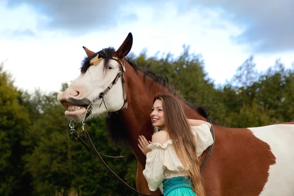 Mooie vrouw met een paard in het veld. meisje op een boerderij met een — Stockfoto