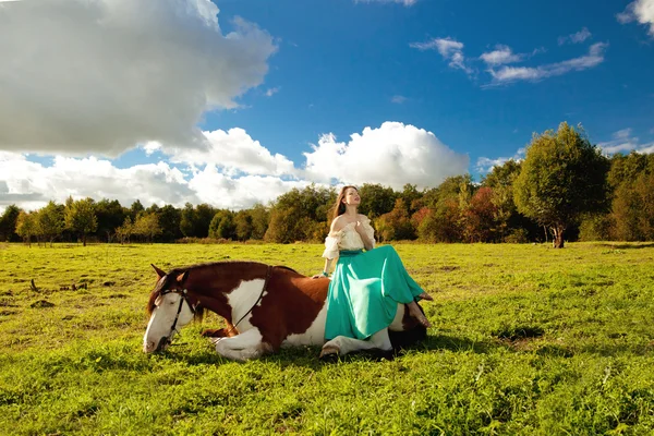 Bella donna con un cavallo nel campo. Ragazza in una fattoria con un — Foto Stock