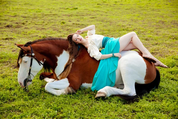 Hermosa mujer con un caballo en el campo. Chica en una granja con un — Foto de Stock