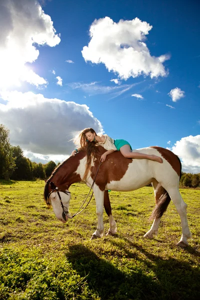 Vacker kvinna med en häst i fältet. flicka på en gård med en — Stockfoto