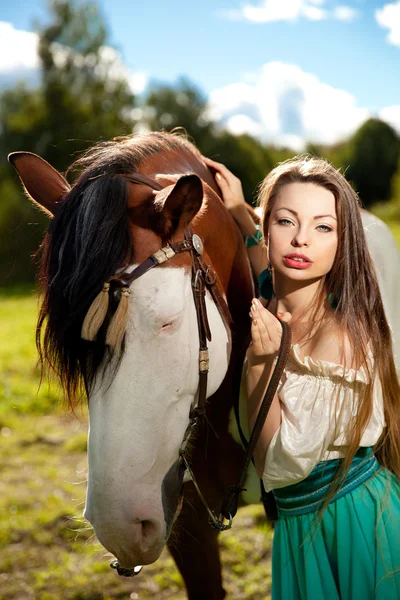 Hermosa mujer con un caballo en el campo. Chica en una granja con un — Foto de Stock