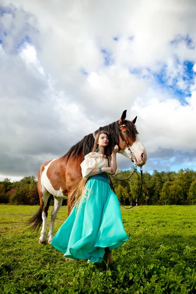 Uma mulher bonita com um cavalo no campo. Menina em uma fazenda com um — Fotografia de Stock