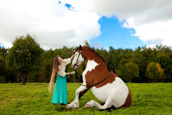 Mooie vrouw met een paard in het veld. meisje op een boerderij met een Rechtenvrije Stockfoto's