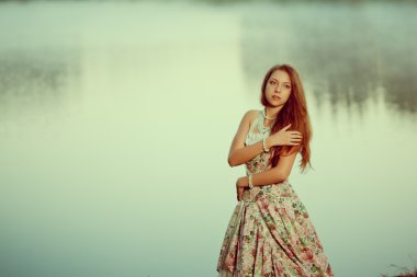 lüks kadın uzun vintage elbise Gölü yakınındaki bir ormanda.