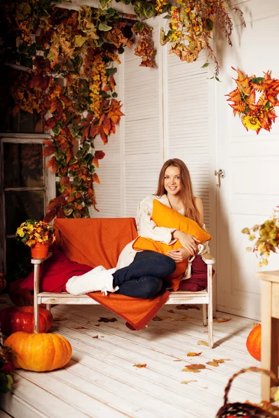 Krásná podzimní žena s úsměvem na verandě, žluté a oranžové — Stock fotografie