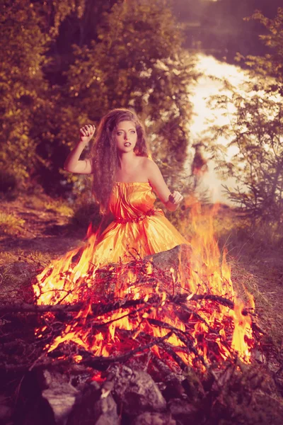 Piękna czarownica w lesie w pobliżu ognia. kobieta magia celebrat — Zdjęcie stockowe