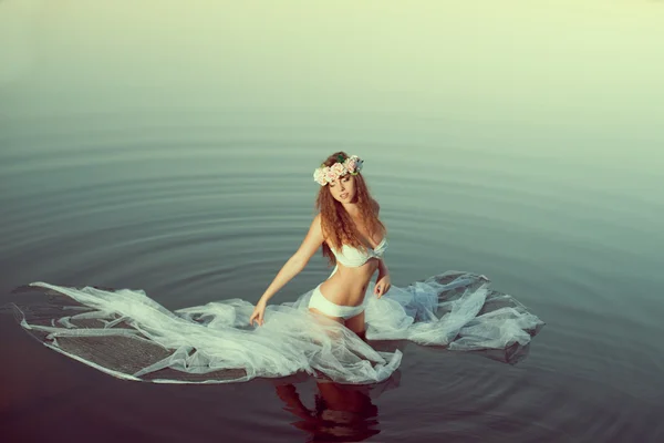 Belle femme dans un lac la nuit. Fille au coucher du soleil dans le lac . — Photo