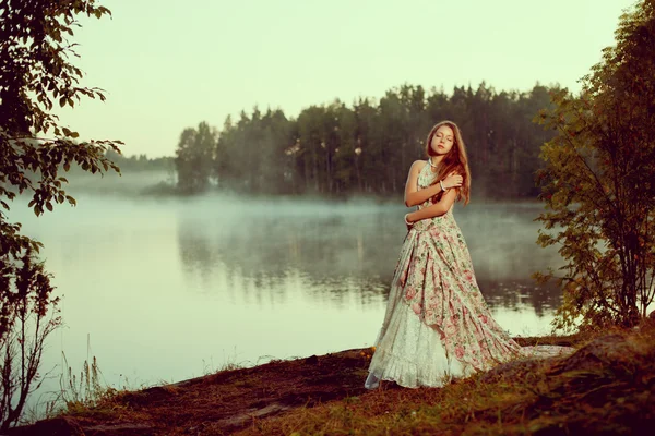 Kobieta luksus w lesie w długo starodawny sukienka w pobliżu jeziora. — Zdjęcie stockowe