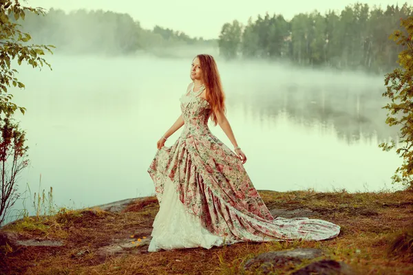 Розкішна жінка в лісі в довгій вінтажній сукні біля озера . — стокове фото
