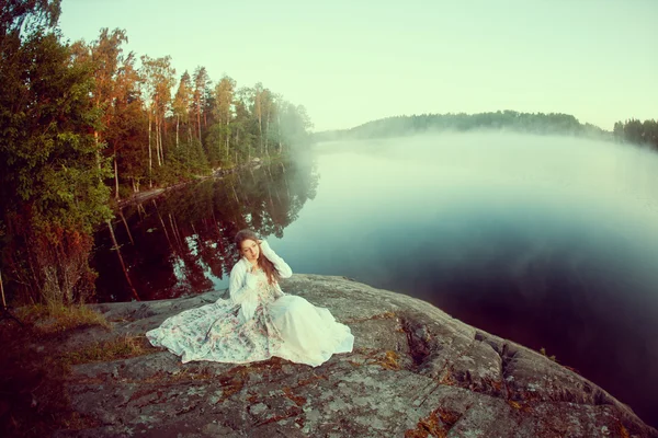 Mujer de lujo en un bosque en un largo vestido vintage cerca del lago . — Foto de Stock