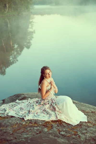 Γυναίκα πολυτέλεια σε ένα δάσος σε ένα πολύ vintage φόρεμα κοντά στη λίμνη. Εικόνα Αρχείου