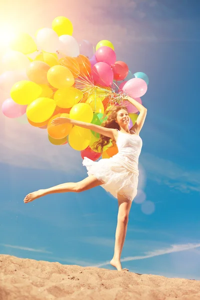 Mooie jonge stijlvolle vrouw met multi-gekleurde regenboog ballon — Stockfoto