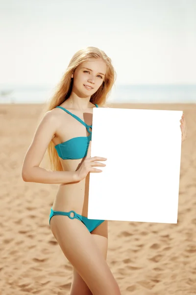 Mulher segurando cartaz branco em branco na praia — Fotografia de Stock