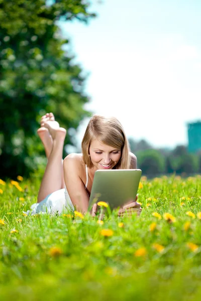 Piękna kobieta uśmiechający się z komputera typu tablet, na zewnątrz. piękne youn — Zdjęcie stockowe