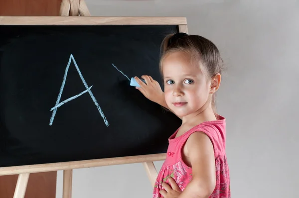 Meisje schrijven op het bord — Stockfoto