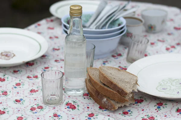 Flaska vodka, färskt bröd och plattor — Stockfoto