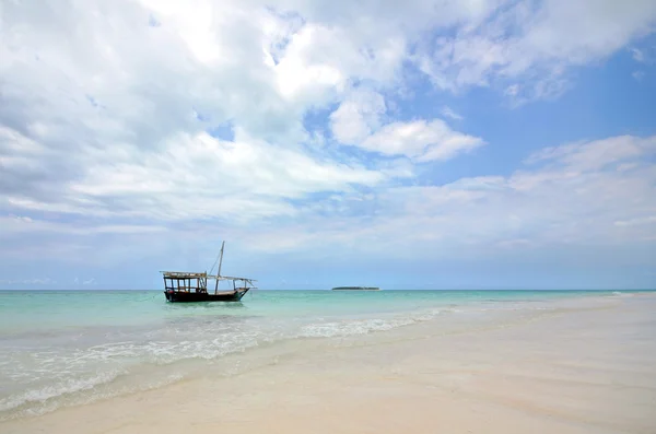 Witte zandstrand met boot en eiland met blauwe hemel — Stockfoto