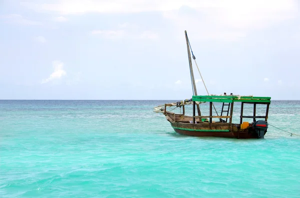 Дерев'яний човен плаває на бірюзовому морі — стокове фото