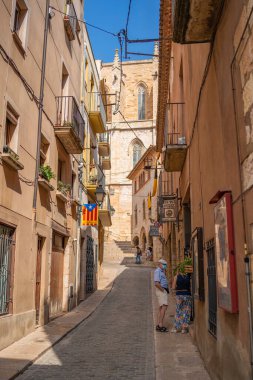 MONTBLANC, İspanya - SEPTEMBER 12.2021: Antik İspanyol köyü Montblanc 'ın tarihi çeyreğinde bir çiftin olduğu eski cadde. dikey