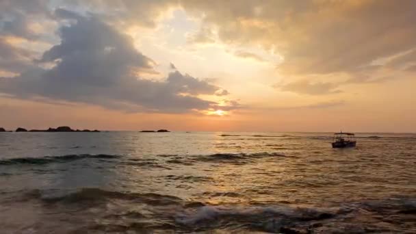 Puesta de sol en la playa tropical de Hikkaduwa con un barco, Sri Lanka — Vídeos de Stock