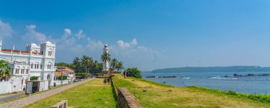 GALLE, SRI LANKA - 24 Aralık 2021: Arka planda eski deniz feneri, panorama ile Galle 'deki kalenin yolu