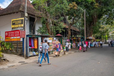 KANDY, SRI LANKA-ARALIK 30.2021: Sokak satıcısının görüntüsü ve Kandy 'deki tapınağın etrafında satılacak mallar