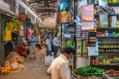 KANDY, SRI LANKA - 30 Aralık 2021: Sri Lanka 'daki Kandy Market' te meyve tezgahlarının önünde yürüyen insanlar